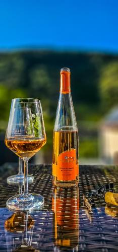 a bottle of wine and a glass on a table at Pension Andries in Ernst