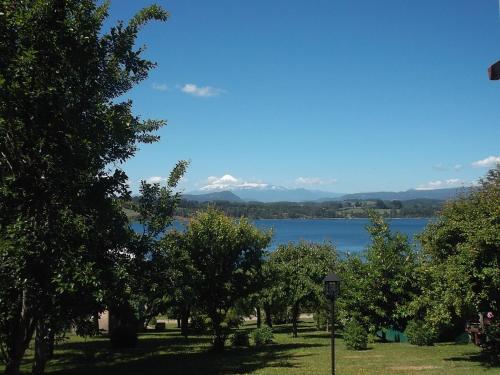 a view of a lake with trees and mountains at Apart hotel Puchaley Lafquen in Panguipulli