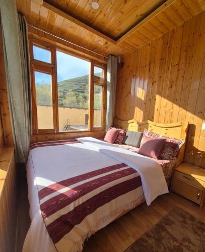 a large bed in a room with a window at The Sunflower Homes in Gondla