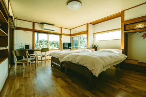 a bedroom with a large bed and a dining room at ゲストハウス蘖 -ひこばえ in Kitakami