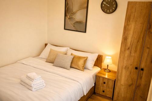 a bedroom with a bed with a clock on the wall at The Forest Retreat in Mihăeşti