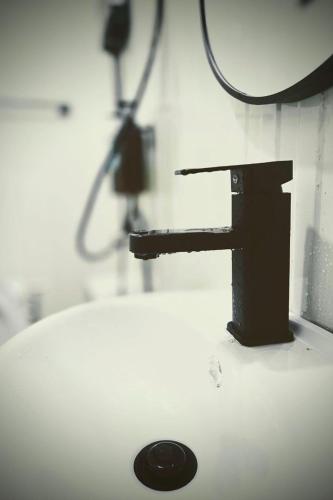 a bathroom sink with a black faucet at Kua Car Camp in Lampang