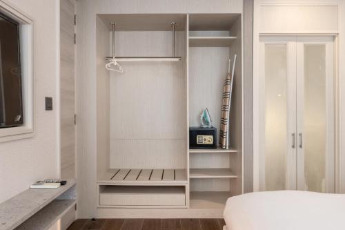 a bedroom with a walk in closet with shelves at Bayphere Residence Private Beach With Fitness and Pool in Na Jomtien