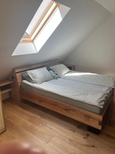 a bedroom with a bed with a skylight at Apartmaji pri Mojci in Podvelka