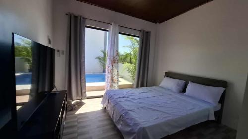 a bedroom with a bed and a large window at Isla Del Mar Villas in Panglao Island