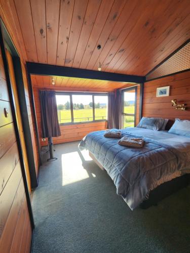 a bedroom with a large bed in a wooden room at Ruapehu Farm Chalet in Ohakune