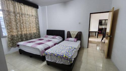 a bedroom with two beds and a mirror at The Gladiator Homstay in Brinchang