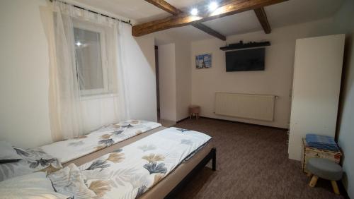 a bedroom with a bed and a window at Kun Kuckó Vendégház in Kiskunmajsa