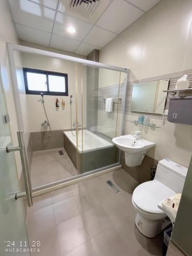 a bathroom with a shower and a toilet and a sink at Shiyue Homestay in Zhuangwei