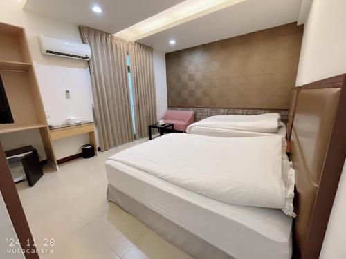 a hotel room with two beds and a television at Shiyue Homestay in Zhuangwei