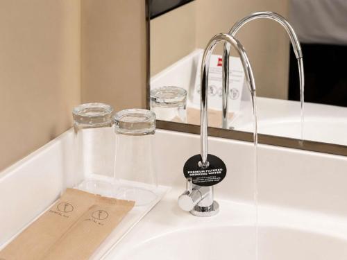 a bathroom sink with a faucet and a tag on it at Ibis Singapore Novena in Singapore