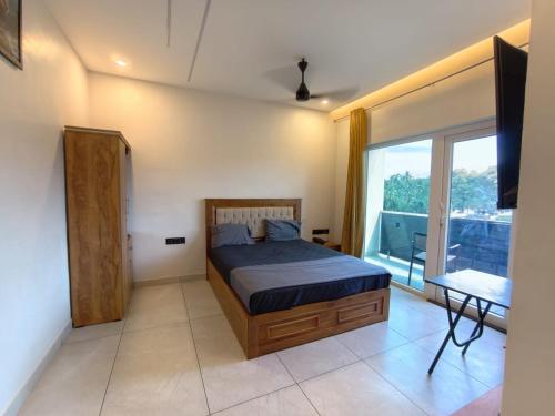 a bedroom with a bed and a large window at Falls Regency in Kaliyal