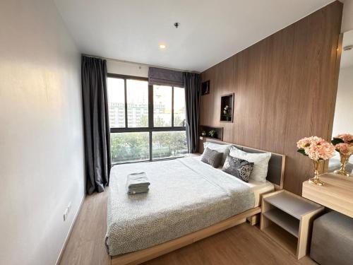 a bedroom with a large bed and a window at Sanphawut IDEO CONDO in Bang Chak
