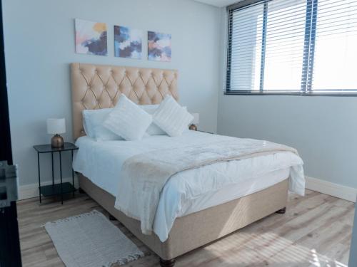 a white bedroom with a large bed and a window at 77 ON Independence Avenue in Windhoek