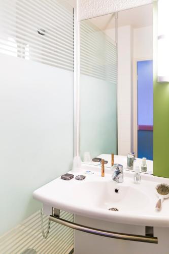 a bathroom with a white sink and a mirror at ibis budget Toulouse Centre Gare in Toulouse