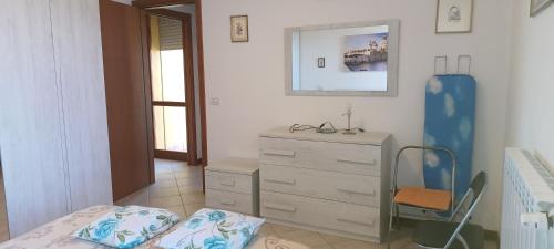 a bedroom with a bed and a dresser and a mirror at Abate Appartament in Correzzola