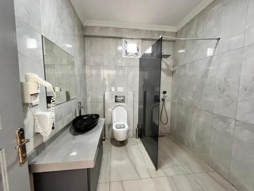 a bathroom with a toilet and a sink and a shower at Deniz Hotel Kumburgaz in Büyükçekmece