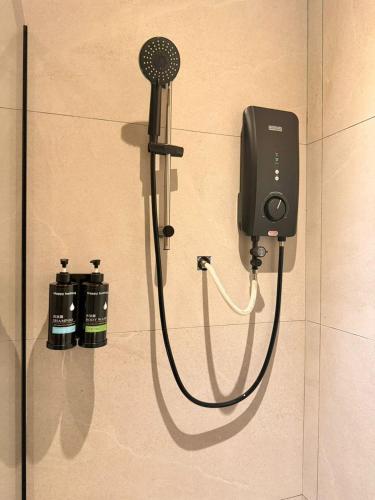 a shower with a blow dryer attached to a wall at I Fly Hotel BSI in Tawau