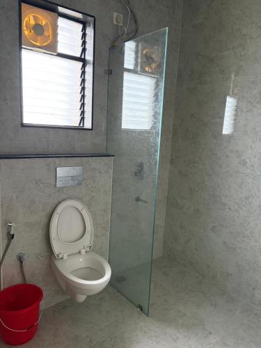 a bathroom with a toilet and a window and a glass shower at Md Couple Stay in Covelong