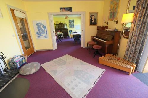 a room with a piano and a room with a table at Frauenpension Arleta - Women only in Goslar