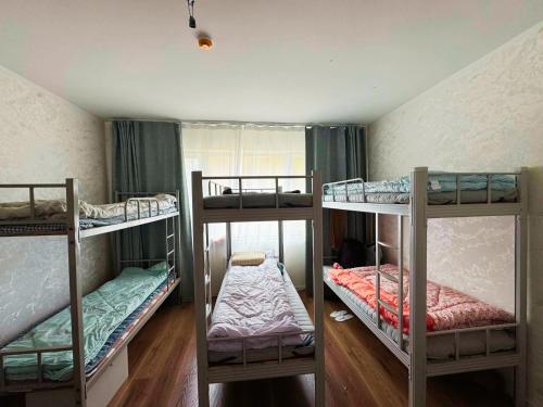a room with three bunk beds in it at Sunrise Guesthouse UB in Ulaanbaatar