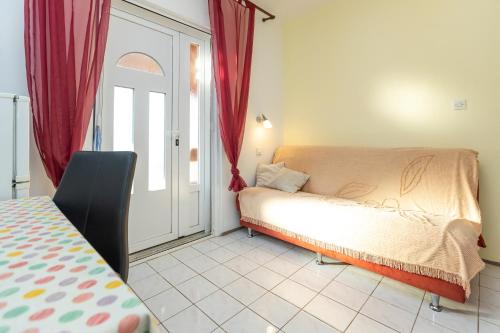 a bedroom with a bed and a window with red curtains at Apartments Diana in Luka