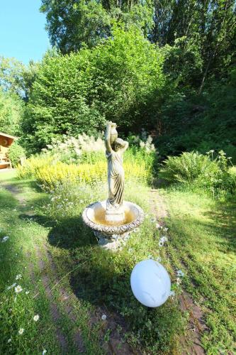 a statue of a woman standing in a garden at Frauenpension Arleta - Women only in Goslar