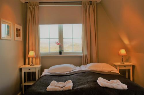 a bedroom with two towels on a bed with a window at The White House in Reykholt