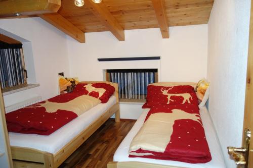 two beds in a room with red comforter at Katja´s Ferienwohnung in Trins