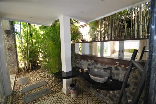 a bathroom with a sink and some plants at Villa Pantai Matanai in Tianyar