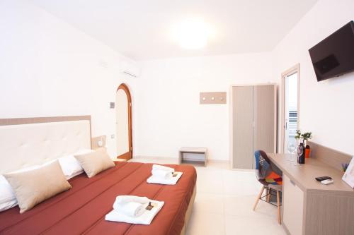 Habitación grande de color blanco con cama grande y escritorio. en Il Gallo Con Gli Stivali en Termoli
