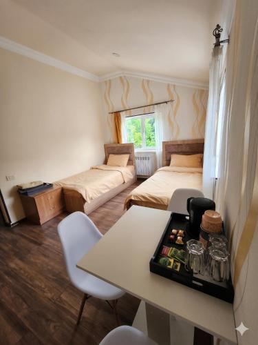 a room with two beds and a table and chairs at Dilijan Rest - Comfortable rooms & Pool in Dilijan