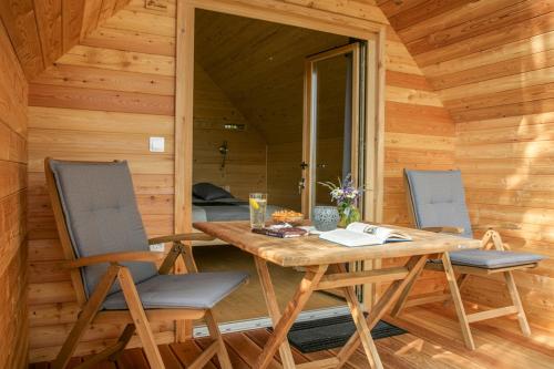 a wooden table and two chairs in a cabin at Glamping Kranjc in Kobarid