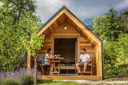 a couple sitting at a table in a tiny house at Glamping Kranjc in Kobarid