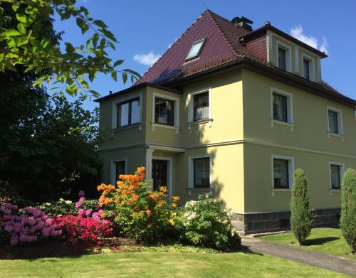 a house with flowers in the yard at Ferienwohnung Zum Gartenparadies in Oppach