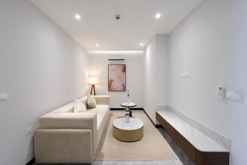 a white living room with a couch and a table at Osea Hotel in Sihanoukville