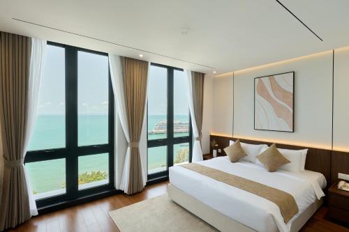 a bedroom with a large bed and large windows at Osea Hotel in Sihanoukville