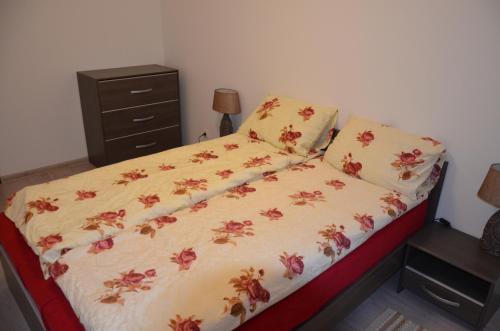a bedroom with a bed with a floral bedspread at Apartments Ozo Park in Vilnius