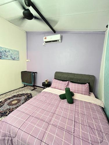 a bedroom with a purple bed with a teddy bear on it at Homestay Teera in Chemor