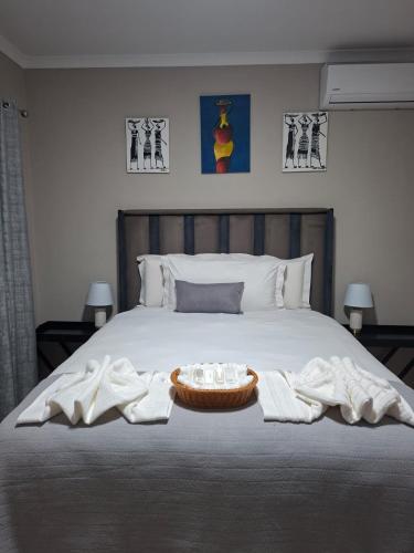 a bedroom with a bed with towels on it at House Sawubona in Kroonstad