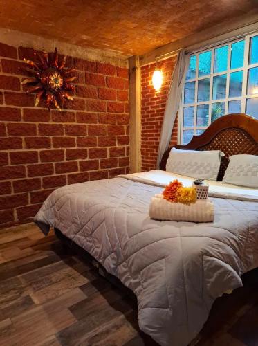 ein Schlafzimmer mit einem großen Bett und einer Backsteinwand in der Unterkunft Chalet MQSTO in La Cañada
