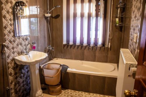 a bathroom with a sink and a bath tub and a sink at Amberwoodinn in Munglor