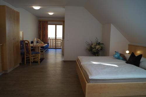 a bedroom with a large bed and a dining room at Haus Garz in Weissensee