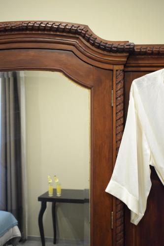 a mirror with two candles on a table in a room at Cento Tari' Guest House in Castiglione di Sicilia
