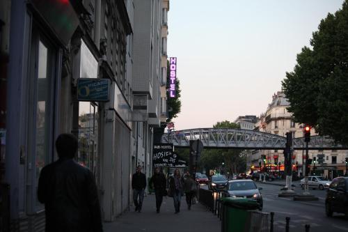 a group of people walking down a city street at Peace & Love Hostel in Paris