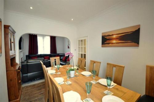 a dining room with a table with chairs and a couch at Ocean House - Weymouth in Weymouth