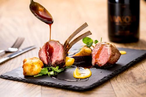 a plate of food with meat and vegetables on a table at Hazlewood Castle & Spa in Tadcaster
