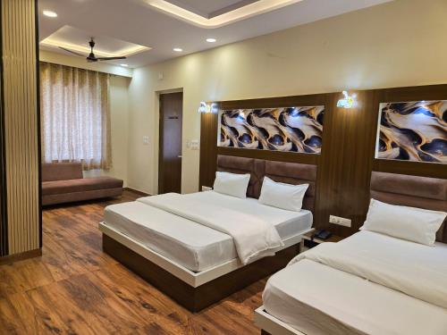 a bedroom with two beds and a couch at Pink Mahal Hotel & Resort in Jaipur