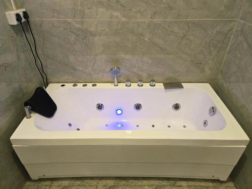 a white bath tub in a bathroom with at Pink Mahal Hotel & Resort in Jaipur