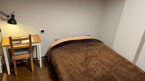 a small bedroom with a bed and a desk at Easy Stay Chichibu in Chichibu